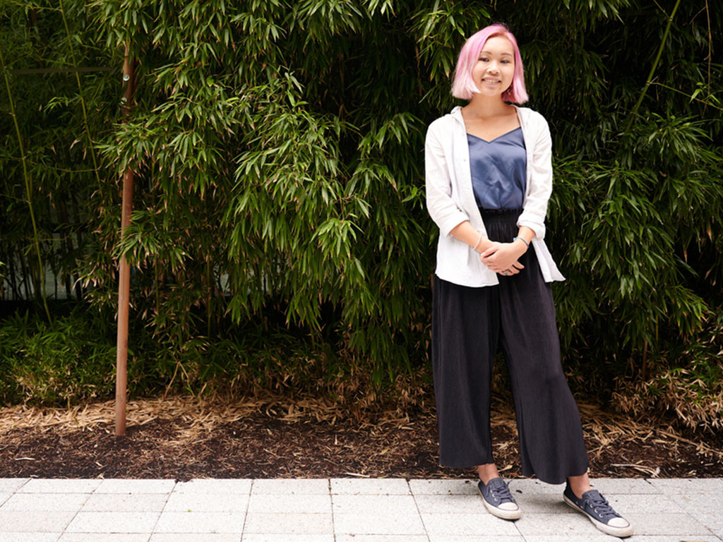 Susan Su stands in a courtyard with tall bamboo in background